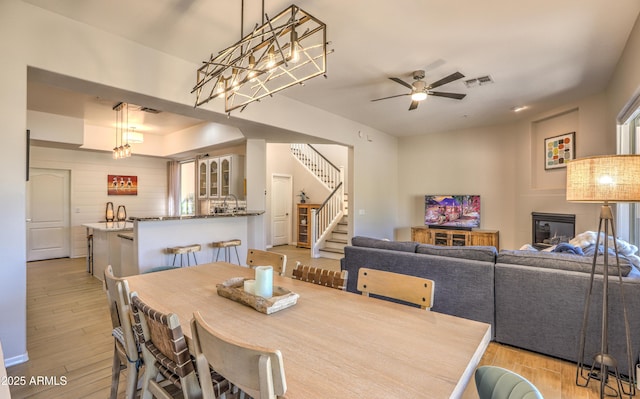 dining space featuring ceiling fan, sink, and light hardwood / wood-style floors