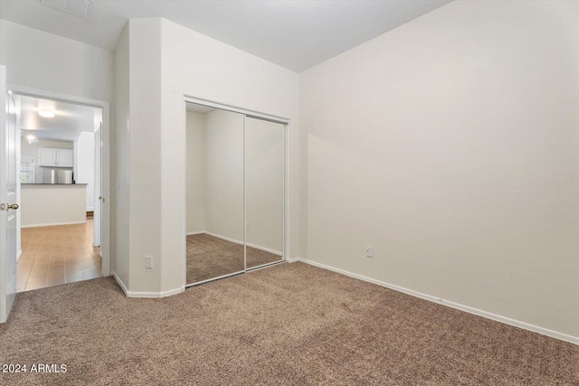 unfurnished bedroom with a closet and carpet floors