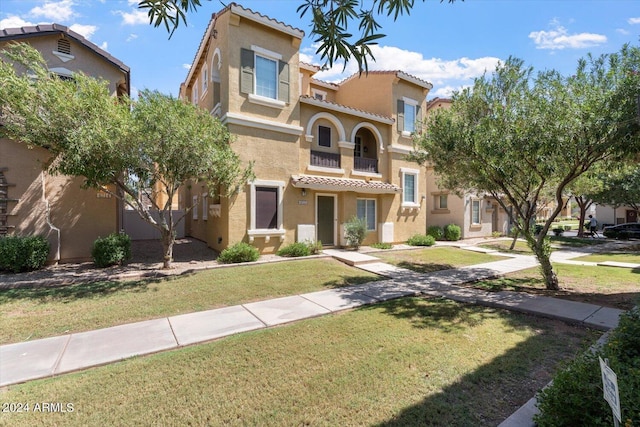 mediterranean / spanish home with a front lawn