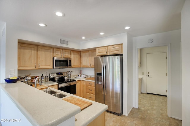 kitchen with a sink, appliances with stainless steel finishes, and light brown cabinets