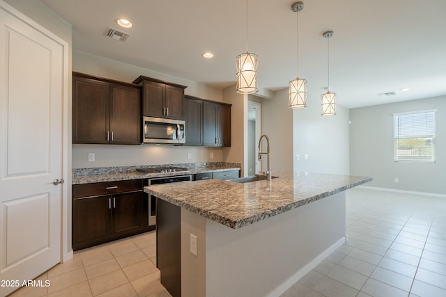 kitchen featuring light tile patterned floors, visible vents, stainless steel appliances, and a sink