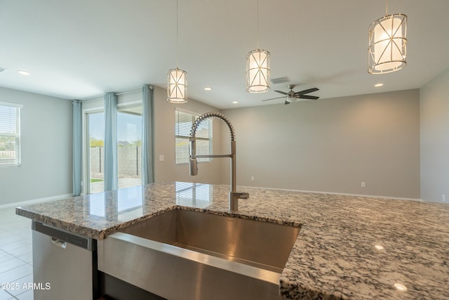 kitchen featuring light stone countertops, recessed lighting, stainless steel dishwasher, and a sink