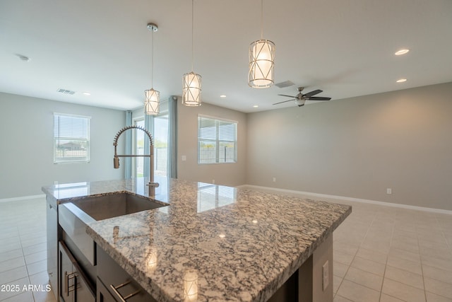 kitchen with a sink, light tile patterned floors, visible vents, and a wealth of natural light