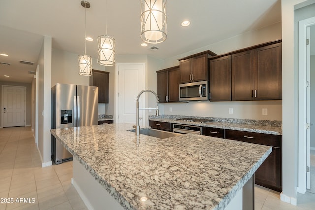 kitchen featuring recessed lighting, light tile patterned floors, stainless steel appliances, dark brown cabinets, and a sink