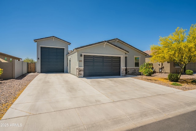 view of front facade featuring an attached garage, driveway, stone siding, stucco siding, and fence