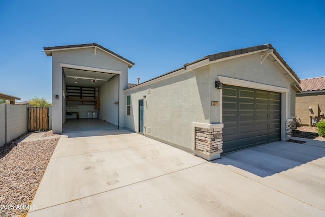 garage featuring fence and concrete driveway