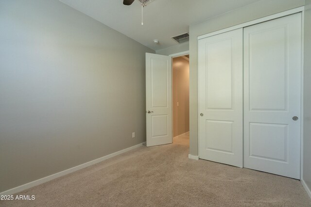 unfurnished bedroom with a closet, vaulted ceiling, light carpet, baseboards, and visible vents