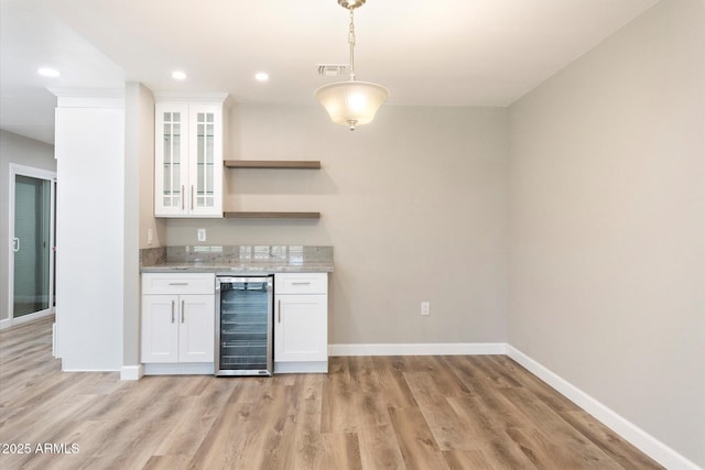 kitchen with beverage cooler, open shelves, visible vents, and white cabinetry