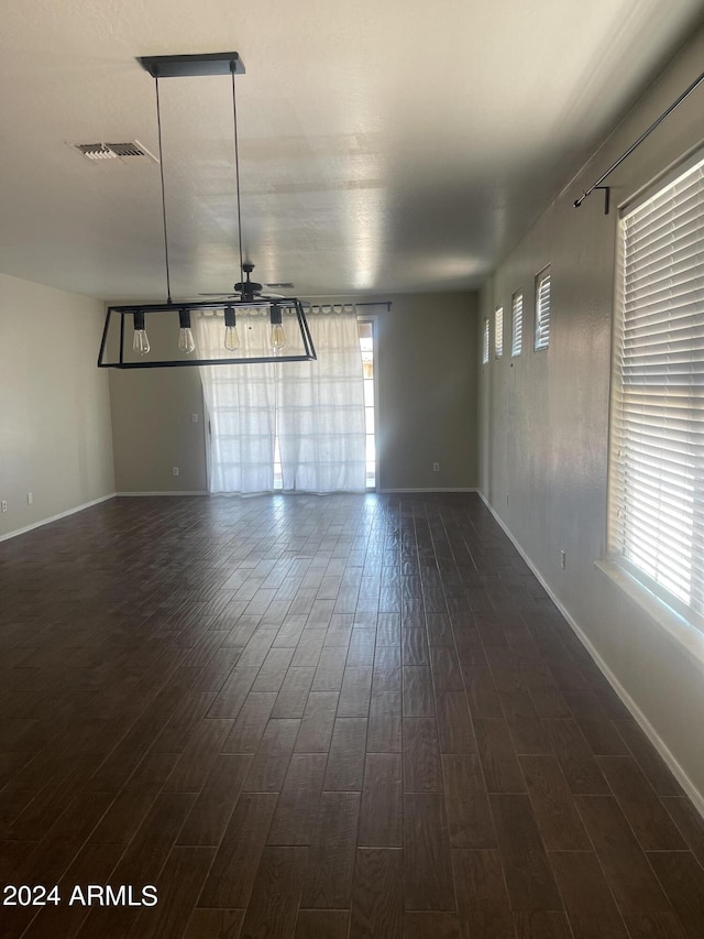 spare room featuring ceiling fan and dark wood-type flooring