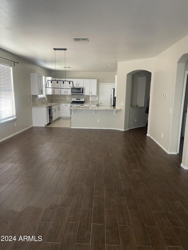 unfurnished living room featuring sink and dark wood-type flooring