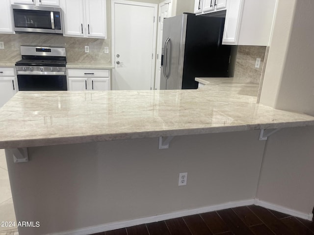 kitchen with kitchen peninsula, stainless steel appliances, and a breakfast bar area