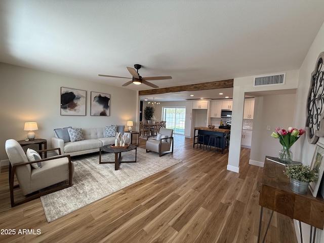 living room with a ceiling fan, visible vents, light wood finished floors, baseboards, and recessed lighting