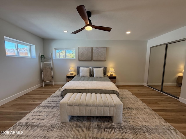 bedroom featuring a ceiling fan, wood finished floors, recessed lighting, a closet, and baseboards