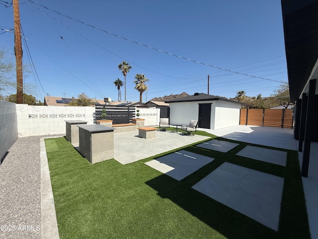 view of yard with an outbuilding, a patio area, and a fenced backyard