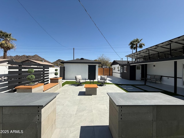 view of patio / terrace with an outdoor structure and fence