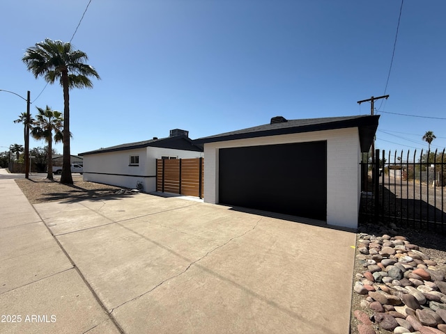 view of front of property featuring a garage, driveway, and fence