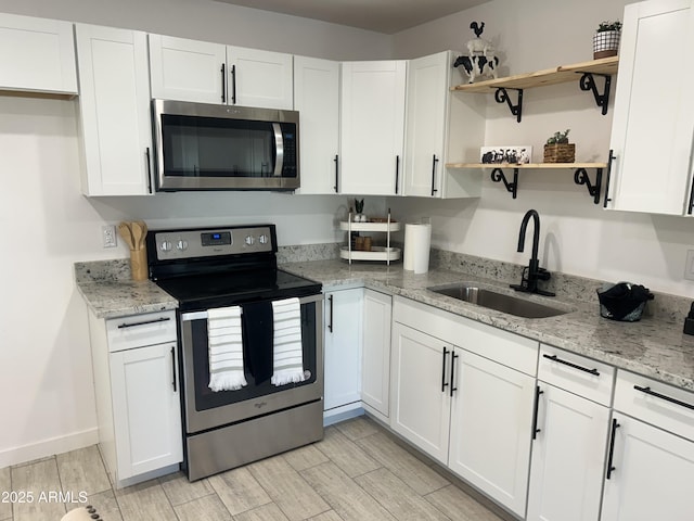 4602 N 47th Ave N, Phoenix, AZ 85031 - kitchen with appliances with stainless steel finishes, a sink, white cabinets, open shelves, and light stone countertops