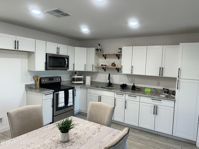 4602 N 47th Ave N, Phoenix, AZ 85031 - kitchen with appliances with stainless steel finishes, a sink, white cabinets, light stone countertops, and light wood-type flooring