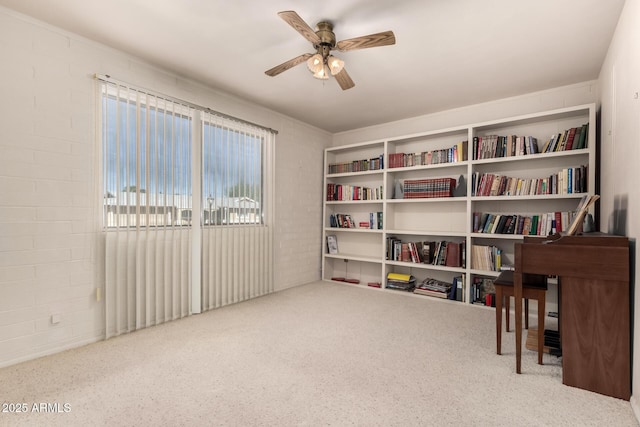 sitting room with brick wall and a ceiling fan