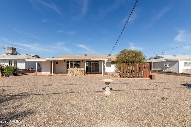 rear view of house with a patio and fence