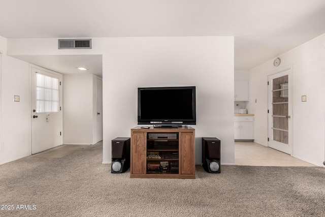 living area featuring visible vents and carpet