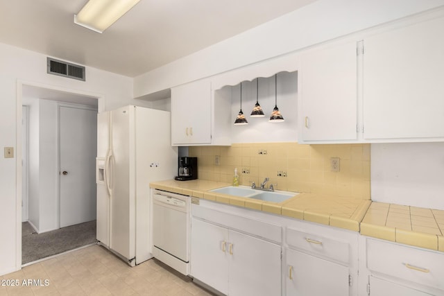 kitchen with a sink, visible vents, white appliances, and white cabinetry