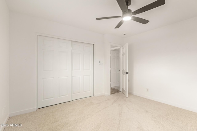 unfurnished bedroom featuring carpet floors, a ceiling fan, baseboards, and a closet