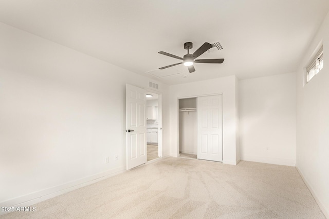 unfurnished bedroom featuring baseboards, visible vents, a closet, and light colored carpet