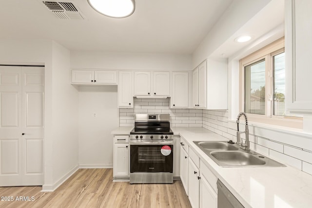 kitchen with visible vents, stainless steel appliances, a sink, and light countertops