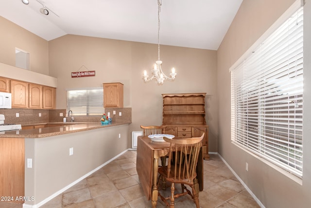 tiled dining room with sink, vaulted ceiling, and a notable chandelier