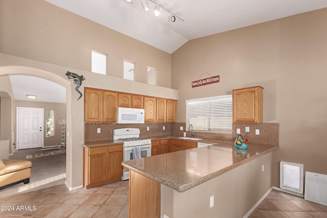 kitchen featuring kitchen peninsula, white appliances, and light tile patterned floors