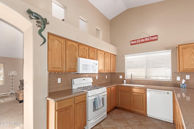 kitchen with light tile patterned floors, high vaulted ceiling, decorative backsplash, sink, and white appliances