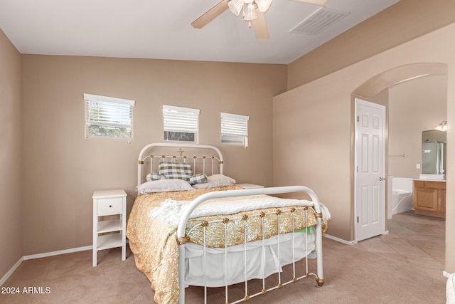 carpeted bedroom featuring connected bathroom, lofted ceiling, and ceiling fan