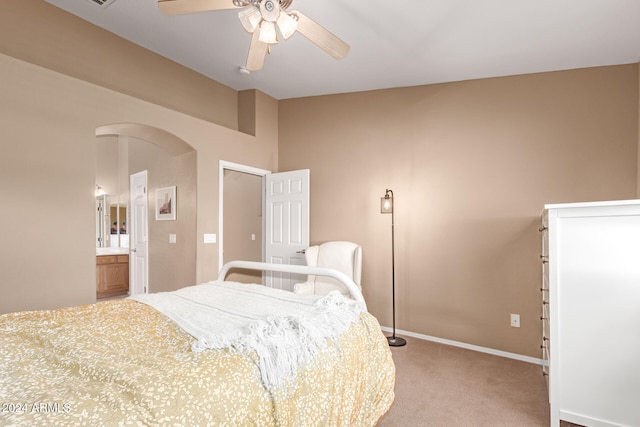 carpeted bedroom with ceiling fan and ensuite bath