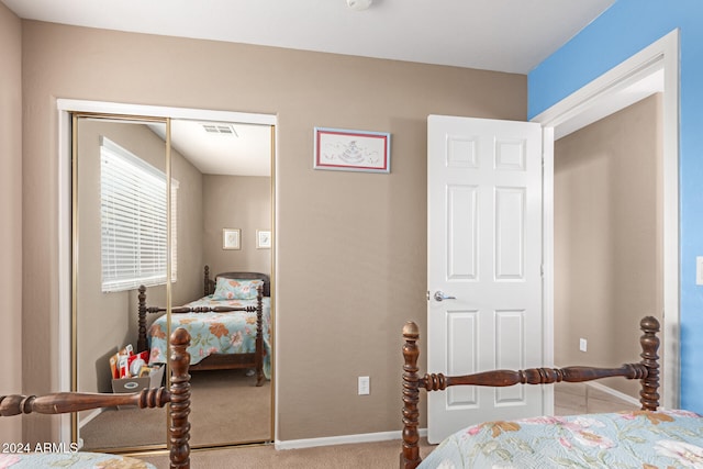 bedroom featuring light colored carpet and a closet