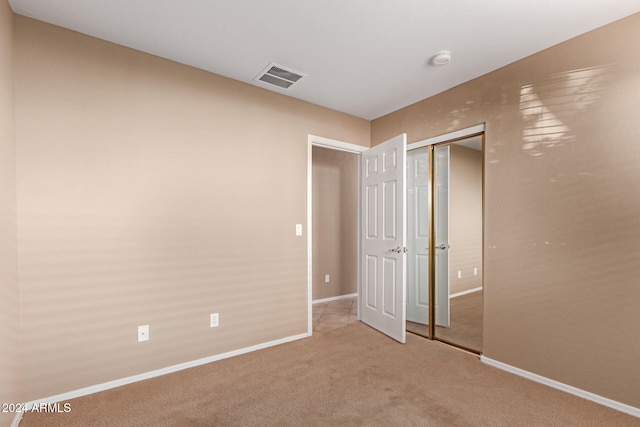 unfurnished bedroom with carpet floors and a closet