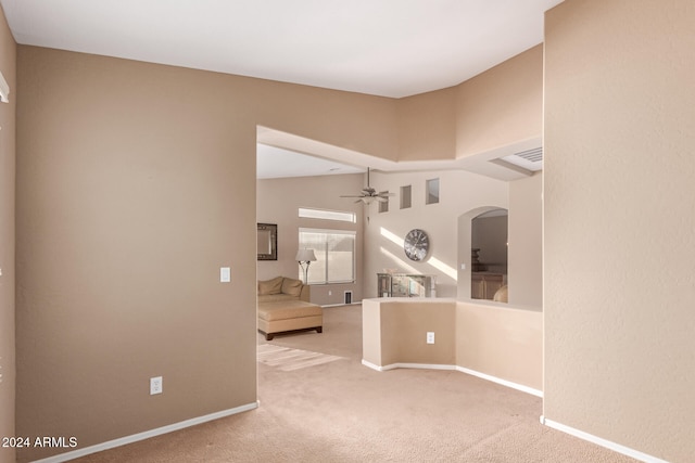 interior space with ceiling fan, carpet flooring, and vaulted ceiling