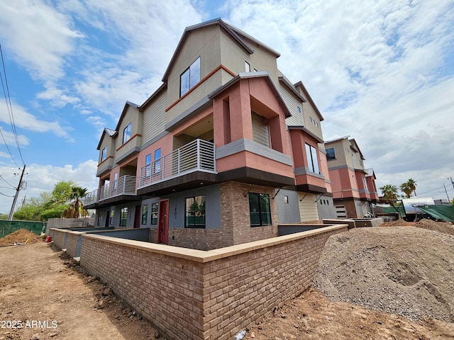 1401 S Rita Ln, Tempe, AZ 85281 - view of property exterior featuring brick siding, a balcony, and stucco siding