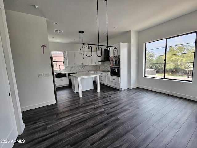 1401 S Rita Ln, Tempe, AZ 85281 - kitchen with white cabinetry, a breakfast bar, dark wood-style flooring, decorative backsplash, and light countertops