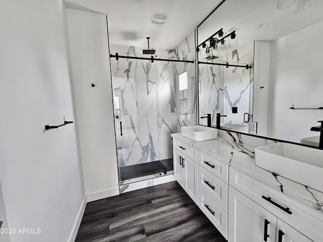 1401 S Rita Ln, Tempe, AZ 85281 - bathroom with double vanity, a marble finish shower, and wood finished floors