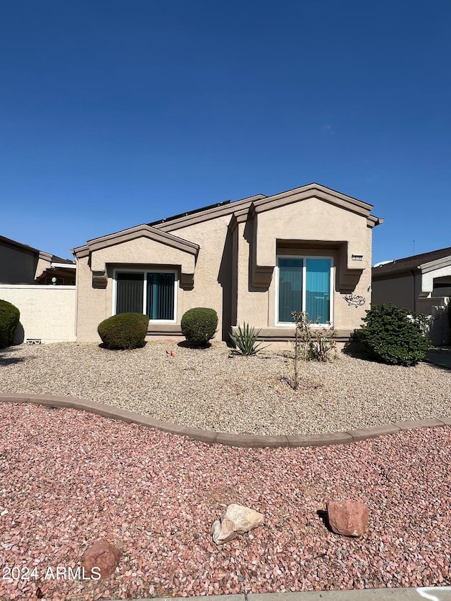 rear view of property with fence and stucco siding