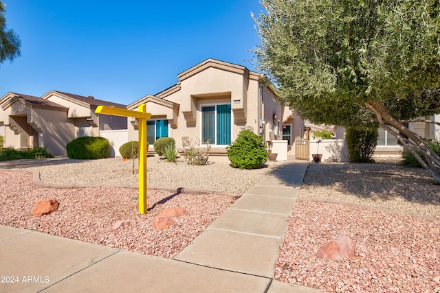 view of front of house featuring fence and stucco siding