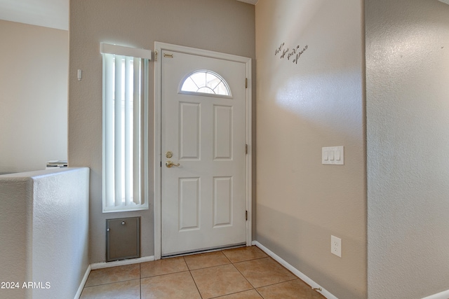 entryway with baseboards and light tile patterned floors