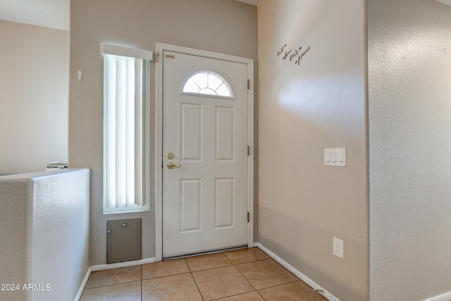 entrance foyer featuring plenty of natural light, light tile patterned flooring, and baseboards