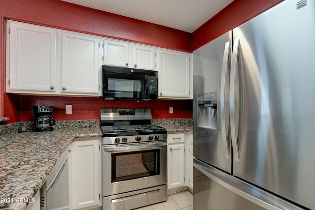 kitchen featuring white cabinets, light stone countertops, stainless steel appliances, and light tile patterned flooring