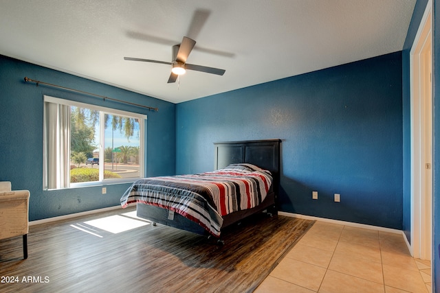 bedroom featuring baseboards, a ceiling fan, and wood finished floors