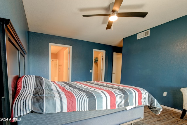 bedroom with connected bathroom, wood finished floors, a ceiling fan, visible vents, and baseboards