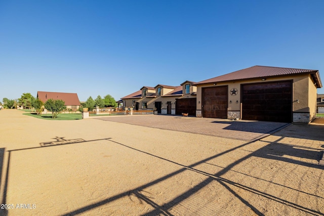 7738 N 185th Ave, Waddell, AZ 85355 - view of front facade with a garage, stucco siding, driveway, and stone siding