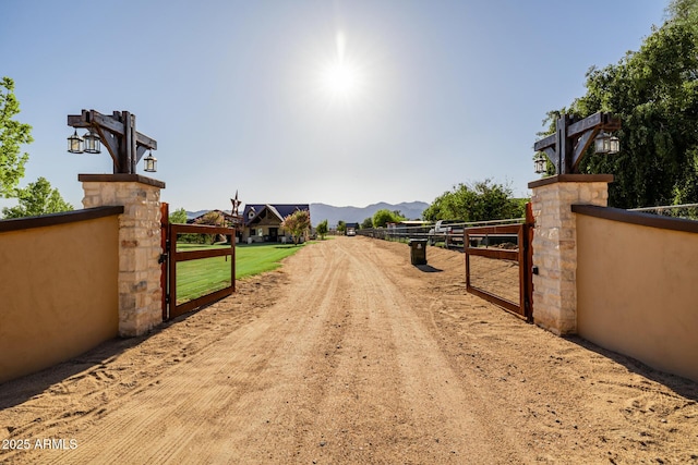 7738 N 185th Ave, Waddell, AZ 85355 - view of road featuring a gate, a gated entry, dirt driveway, and a mountain view