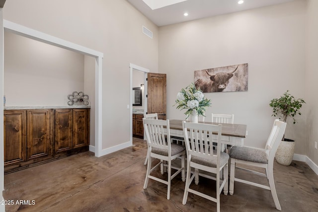 7738 N 185th Ave, Waddell, AZ 85355 - dining room featuring visible vents, finished concrete flooring, baseboards, a high ceiling, and a skylight